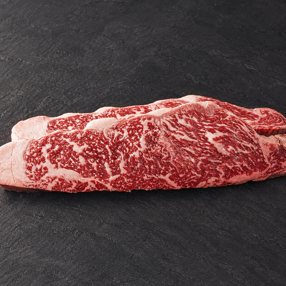 Detalle del lomo bajo de wagyu sobre pizarra. Imagen retocada a partir de la fotografía del producto.